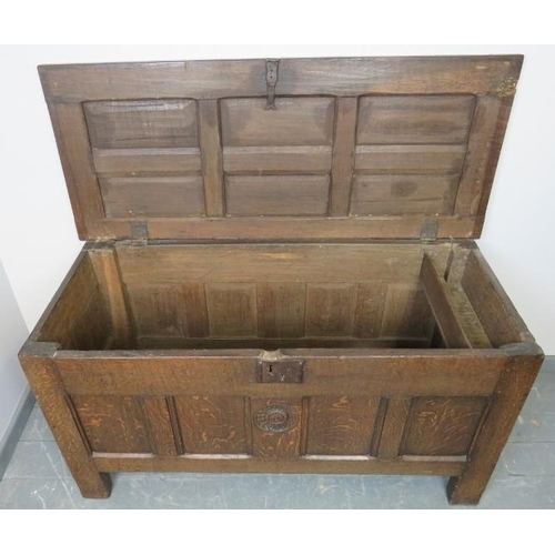 703 - A 17th century panelled oak coffer with fielded panels to top and all four sides and carved central ... 