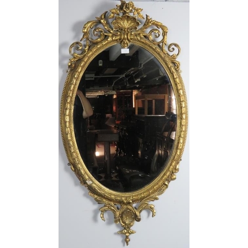 719 - A very ornate 19th century gilt gesso oval wall mirror, with acanthus scrolled shell cornice. 
Condi... 