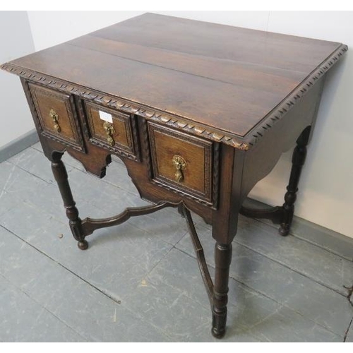 728 - A 19th century oak lowboy in a 17th century taste, housing three short drawers with cast brass drop ... 