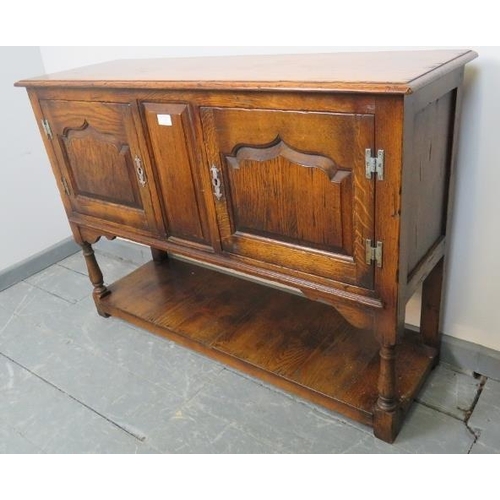 731 - A reproduction medium oak two door side cabinet in the 18th century taste, on turned supports with a... 