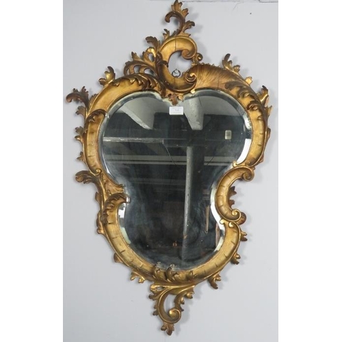 745 - A very ornate 19th century gilt gesso wall mirror, retaining the original asymmetric shaped bevelled... 