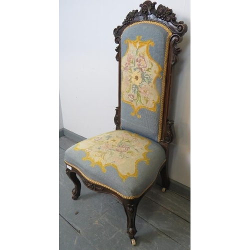 753 - A Victorian show-wood high back tapestry seat nursing chair with ornately carved cornice, on scrolle... 