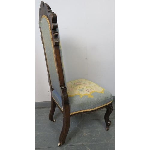 753 - A Victorian show-wood high back tapestry seat nursing chair with ornately carved cornice, on scrolle... 