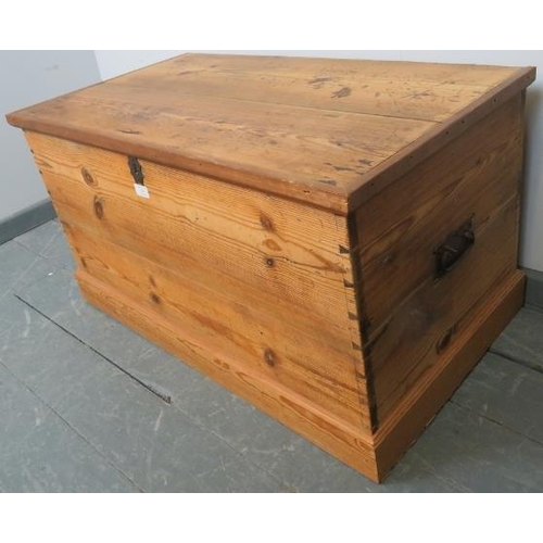 754 - A 19th century pine flat top trunk, with cast iron handles to either side and lock escutcheon, on a ... 