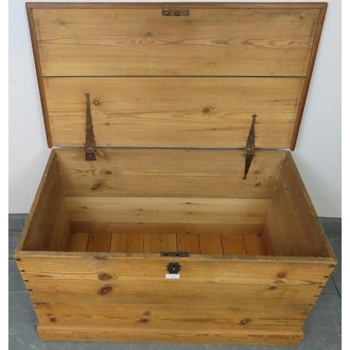 754 - A 19th century pine flat top trunk, with cast iron handles to either side and lock escutcheon, on a ... 