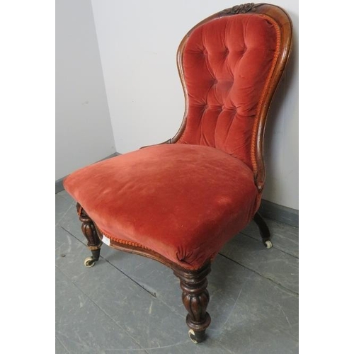 760 - A Victorian mahogany spoonback nursing chair, upholstered in red velvet buttoned material, on taperi... 