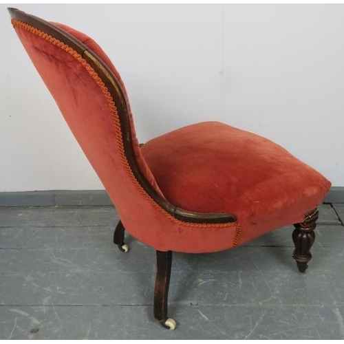 760 - A Victorian mahogany spoonback nursing chair, upholstered in red velvet buttoned material, on taperi... 