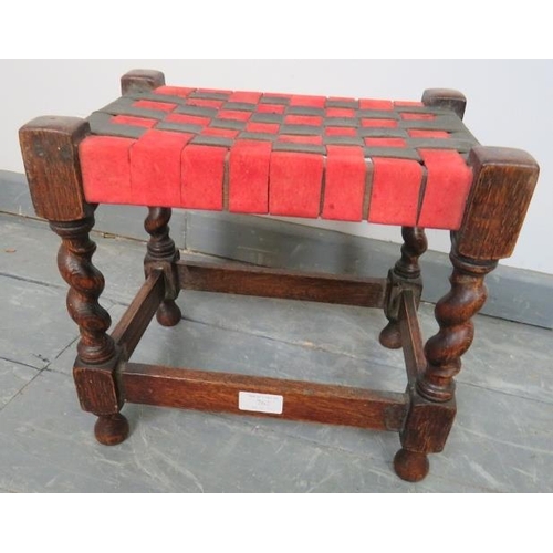 762 - A small vintage oak stool, with black and red strapwork leather seat, on barley twist supports with ... 