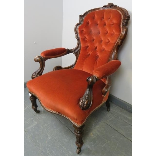 763 - A Victorian mahogany spoon back open sided armchair, upholstered in buttoned red velvet material, on... 