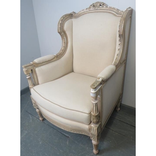 765 - A vintage French wingback armchair in the Louis XV taste, upholstered in a cream material, with reed... 