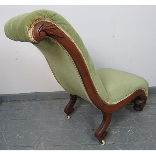 772 - A Victorian mahogany slipper chair, upholstered in buttoned green velvet, on bun feet with ceramic c... 