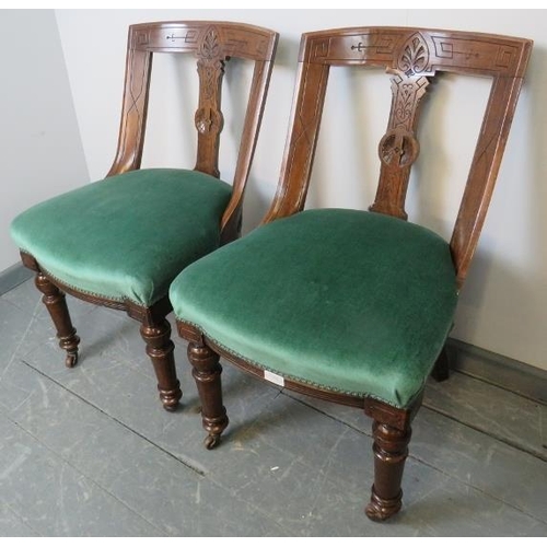 773 - A pair of Aesthetic Period oak low bedroom chairs, with raked and carved backrests, upholstered in t... 