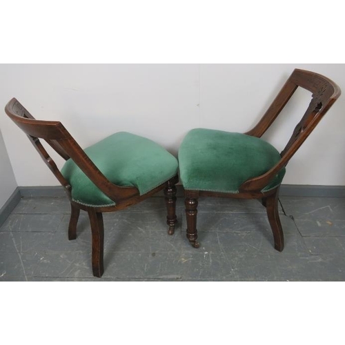 773 - A pair of Aesthetic Period oak low bedroom chairs, with raked and carved backrests, upholstered in t... 