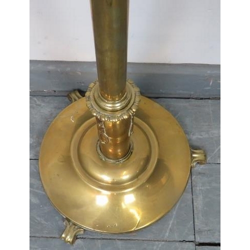 788 - A turn of the century height adjustable brass standard lamp, on an iron weighted plinth base with sc... 