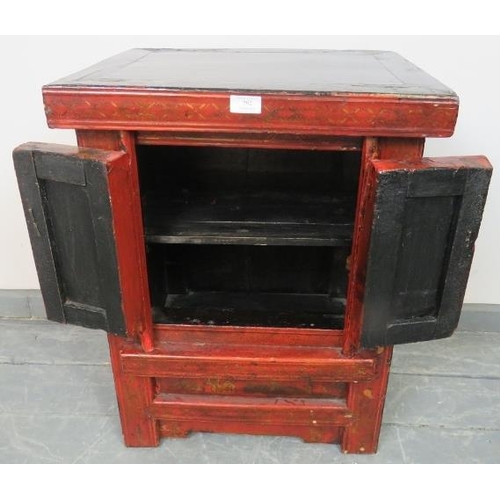 792 - A vintage Chinese red lacquer two door side cabinet, hand painted in black and gold with figural sce... 