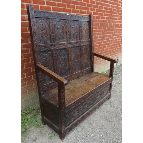 797 - A 19th century high back oak settle in a 17th century taste, featuring relief carved back panels dep... 