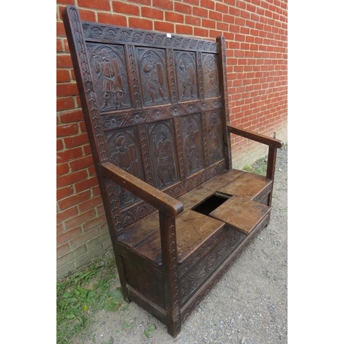 797 - A 19th century high back oak settle in a 17th century taste, featuring relief carved back panels dep... 