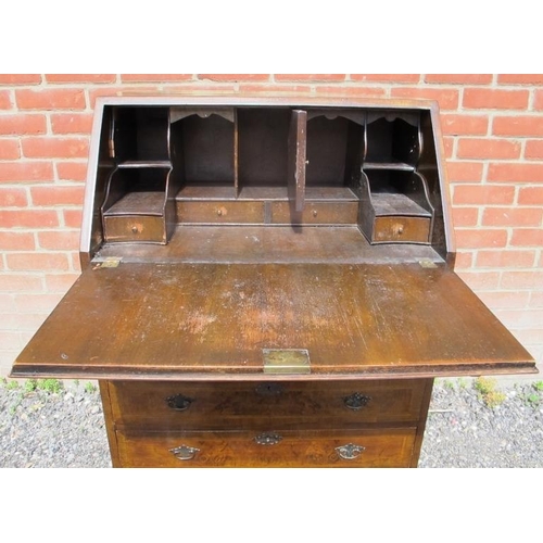 808 - A Georgian Revival walnut bureau, featuring crossbanded inlay, the fall front opening onto a fitted ... 