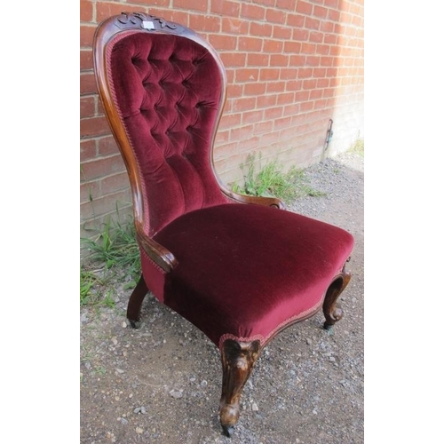 810 - A Victorian mahogany spoonback nursing chair, upholstered in a claret buttoned material, on scrolled... 