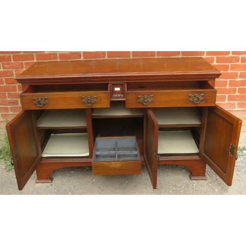 817 - An Art Nouveau carved oak sideboard, housing two short drawers over three cupboards with fitted shel... 