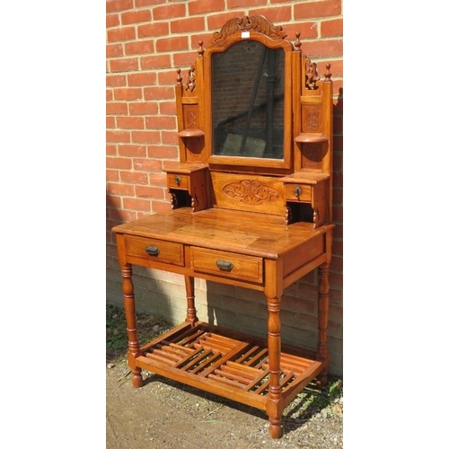 823 - A reproduction fruitwood dressing table in the Victorian taste, with carved cornice and finials, ove... 