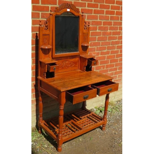 823 - A reproduction fruitwood dressing table in the Victorian taste, with carved cornice and finials, ove... 