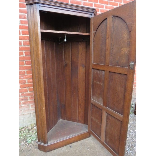 824 - A vintage 18th century style oak freestanding corner cupboard, the panelled door featuring linen fol... 