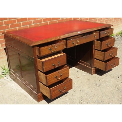 842 - A large vintage mahogany pedestal desk, with inset red leather writing surface, housing a configurat... 