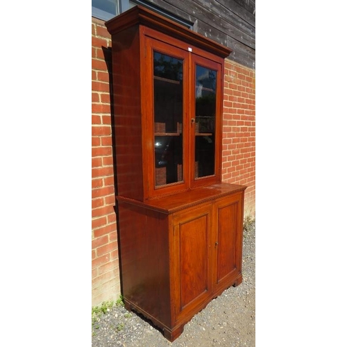 843 - A 19th century walnut glazed bookcase of four height adjustable shelves, with cupboard under housing... 