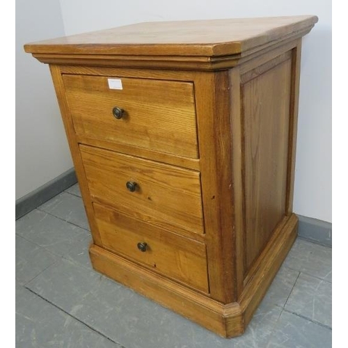 851 - A contemporary light oak bedside chest of three drawers, with fielded side panels, on a plinth base.... 