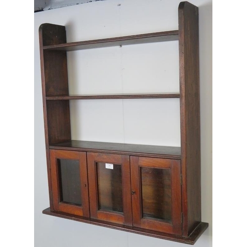 859 - A 19th century mahogany wall hanging unit of three open shelves with small, glazed doors under.
Cond... 