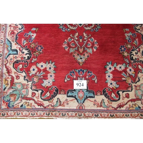 924 - A mid 20th century Persian rug central pattern on red ground. 180cm x 140cm (approx). Some wear to o... 