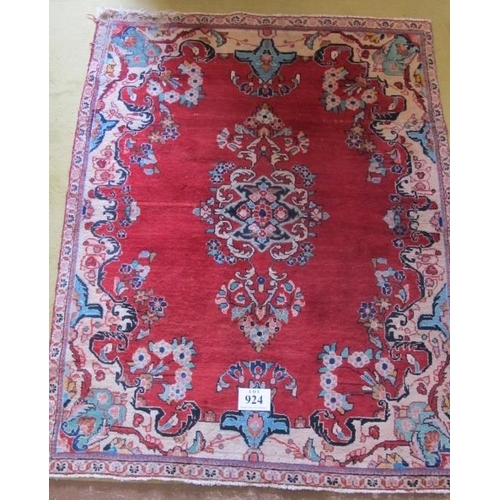 924 - A mid 20th century Persian rug central pattern on red ground. 180cm x 140cm (approx). Some wear to o... 