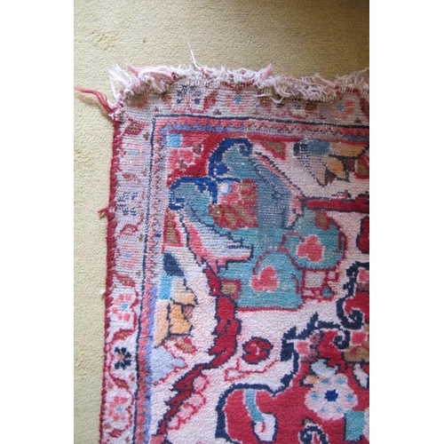 924 - A mid 20th century Persian rug central pattern on red ground. 180cm x 140cm (approx). Some wear to o... 