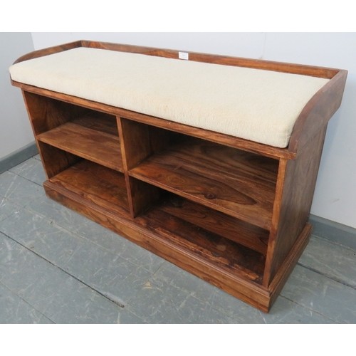 869 - A contemporary hardwood hall bench with fitted seat squab and shelves under, on a plinth base.
Condi... 