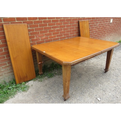 870 - An Arts & Crafts solid light oak wind out extending dining table, with two additional leaves, on tap... 