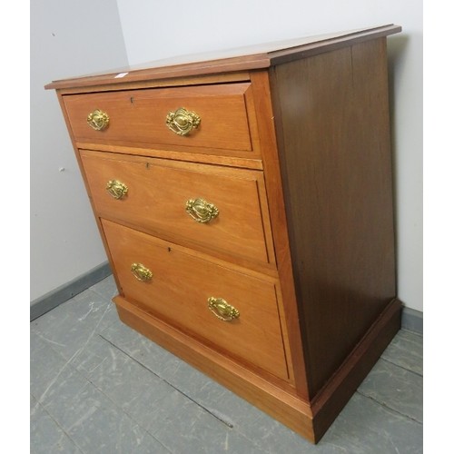 874 - An Edwardian mahogany chest of three long graduated drawers with pressed brass handles, on a plinth ... 