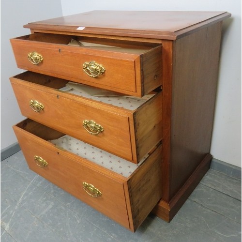 874 - An Edwardian mahogany chest of three long graduated drawers with pressed brass handles, on a plinth ... 