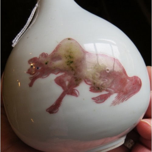 31 - An antique Chinese porcelain bottle vase in white glaze bearing pink decoration of two temple lions ... 