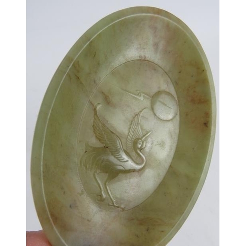 102 - A small carved oval Jade pin dish decorated with a stork looking at the moon. 9cm x 12.5cm.
Conditio... 