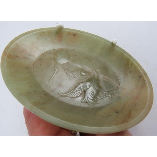 102 - A small carved oval Jade pin dish decorated with a stork looking at the moon. 9cm x 12.5cm.
Conditio... 