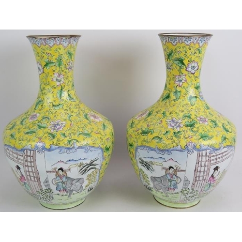 104 - A pair of Chinese Cantonese enamel vases hand decorated with traditional scenes set on a yellow back... 