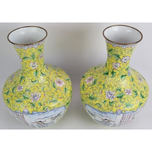 104 - A pair of Chinese Cantonese enamel vases hand decorated with traditional scenes set on a yellow back... 