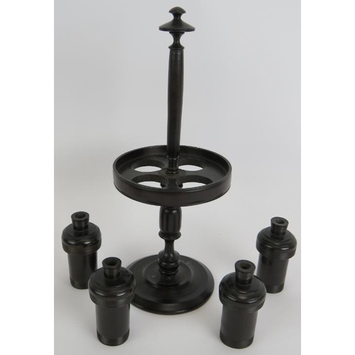 128 - A four piece antique turned ebony gentleman's toilet set including stand with four containers, two l... 