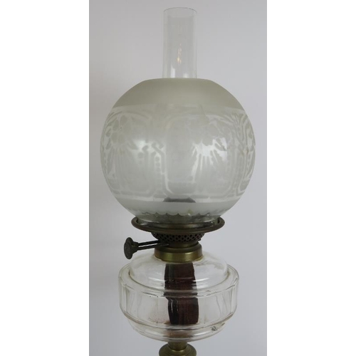 134 - An antique oil lamp with reeded column base, slice cut clear glass reservoir and etched globe shade.... 