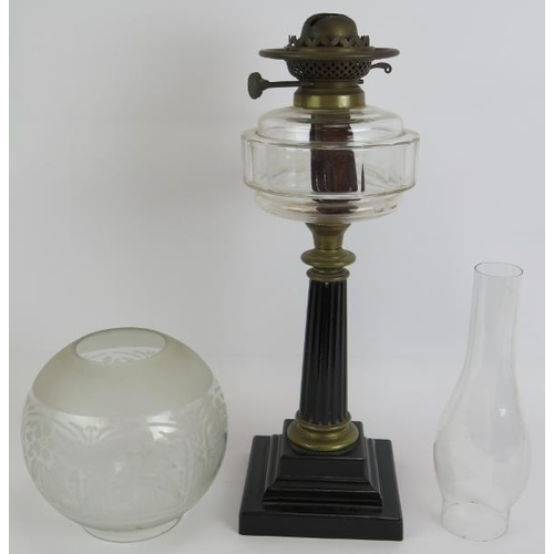 134 - An antique oil lamp with reeded column base, slice cut clear glass reservoir and etched globe shade.... 