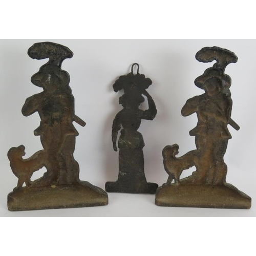 135 - Two antique cast iron doorstops in the form of huntsmen and a cast iron wall hanging in the form of ... 