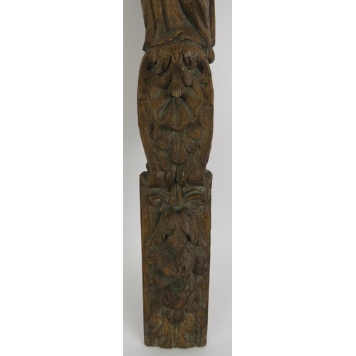 136 - An antique carved oak caryatid of robed figure, probably 17th/18th century. Height 58cm. Width 7.5cm... 