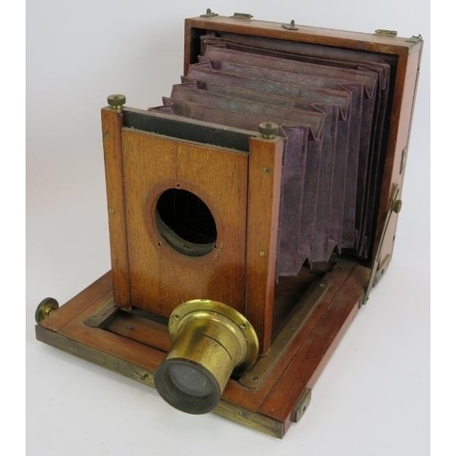 142 - A 19th century mahogany cased plate camera, lens, hood and case with note suggesting manufacture by ... 