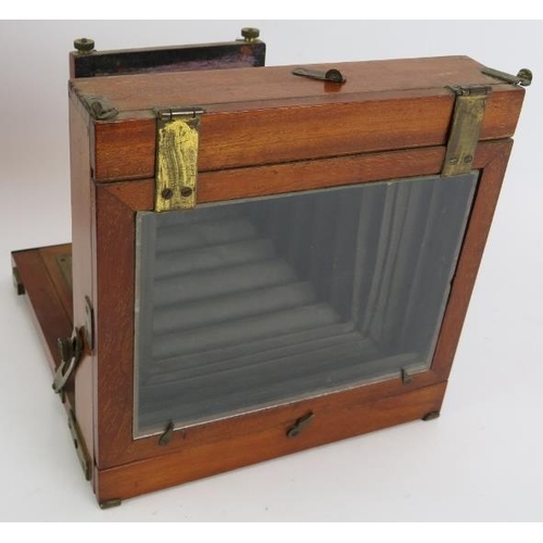 142 - A 19th century mahogany cased plate camera, lens, hood and case with note suggesting manufacture by ... 